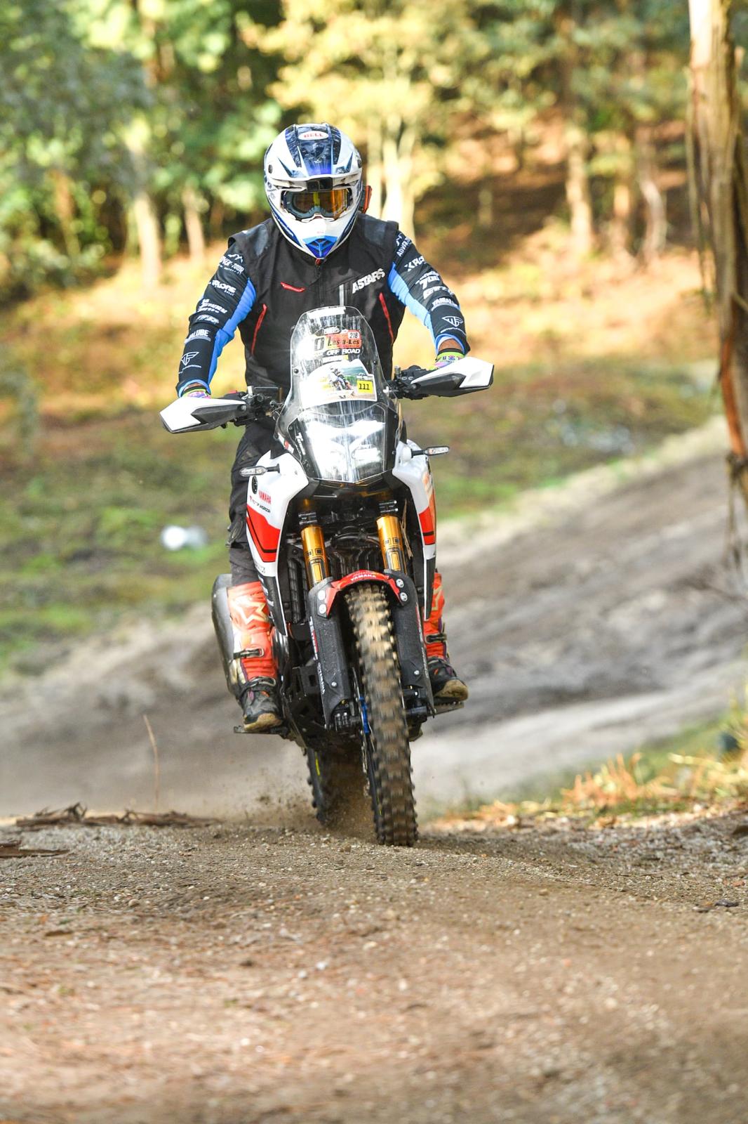 Estradão de serra visto do cockpit de uma Yamaha Ténéré 700, com eólicas no topo do monte